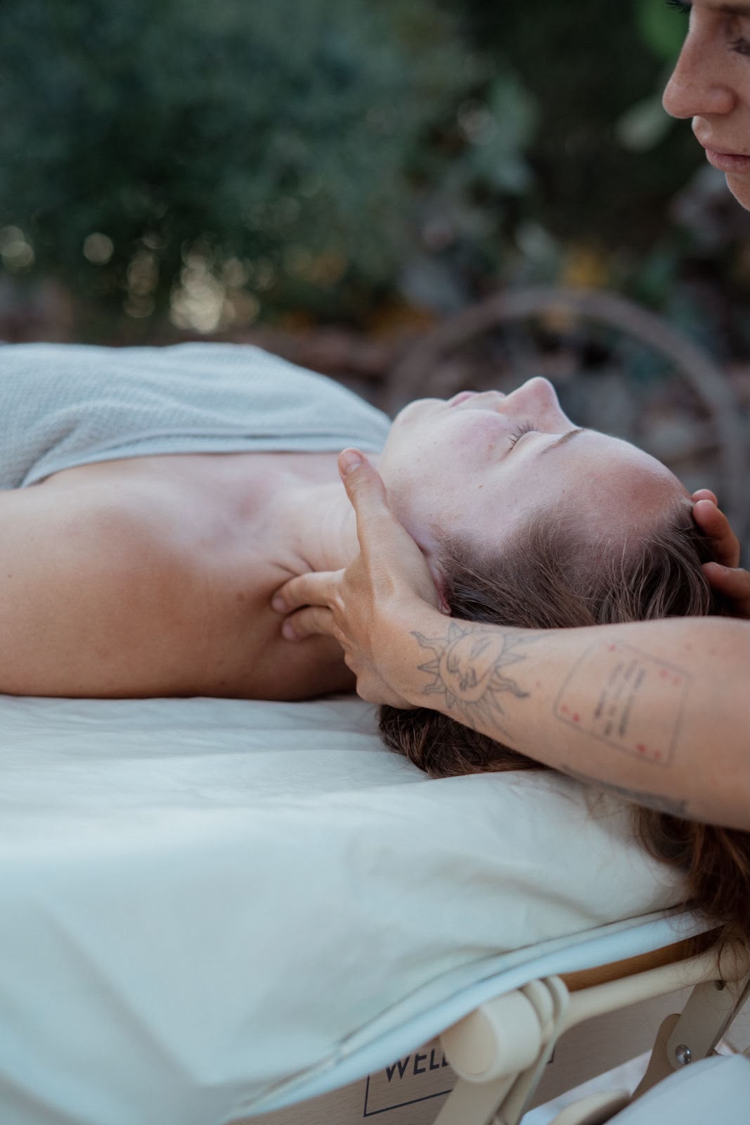 Nackenmassage bei einer liegenden Kundin im Freien